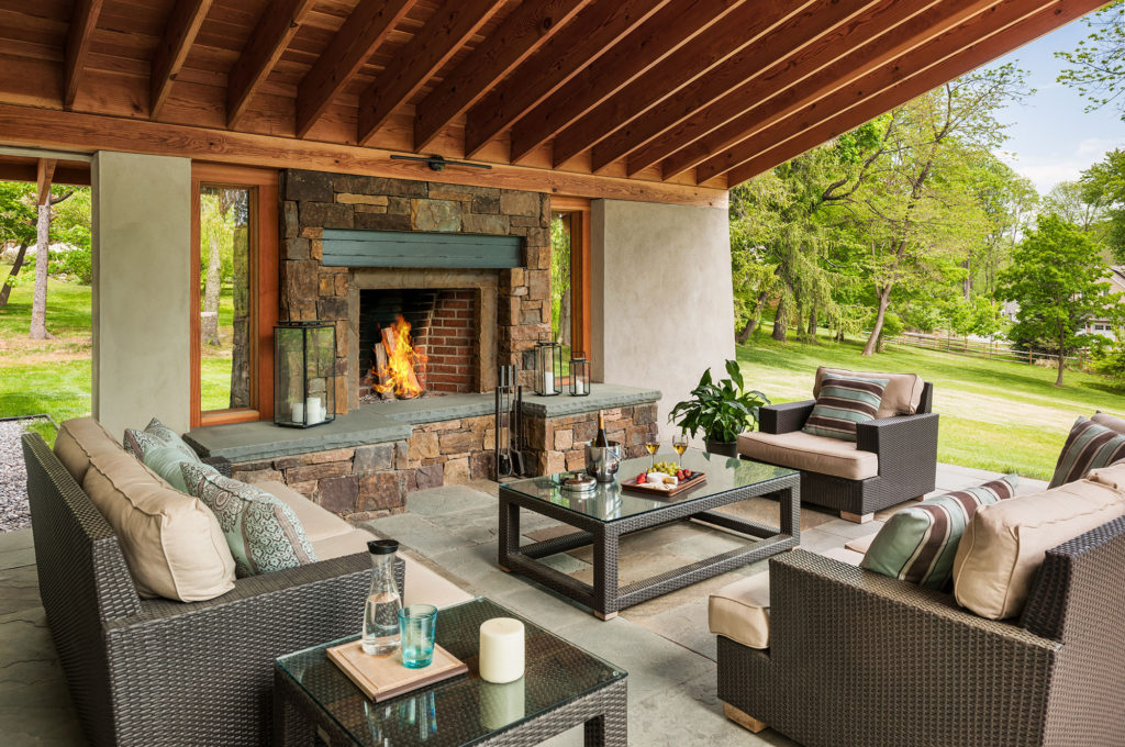 covered outdoor patio with fireplace and seating area