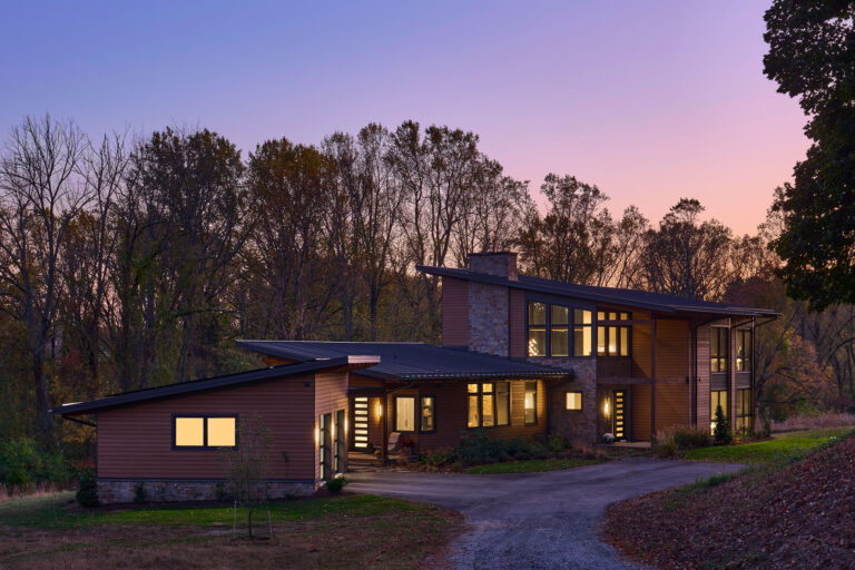 a modern home design seen on approach at dusk