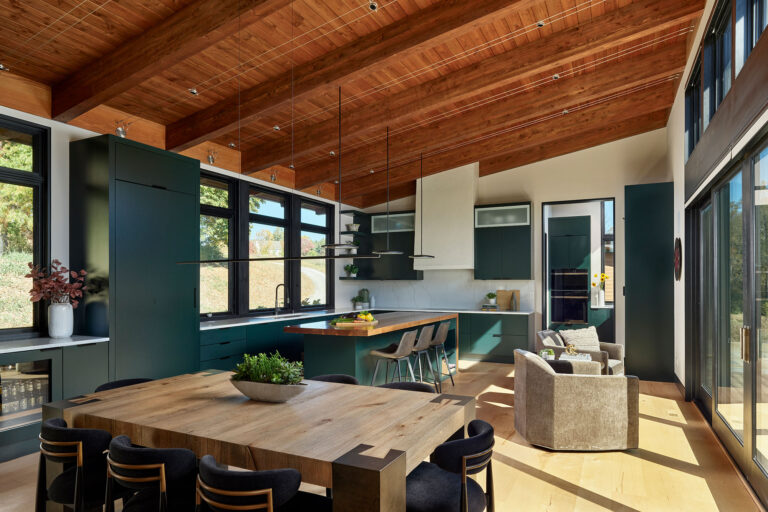 dining and kitchen spaces with green cabinets and wood board ceiling in modern home