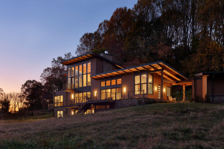 dusk view of modern home design in wooded area